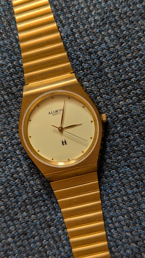 Allwyn Quartz wrist Watch in brushed gold finish and yello dial - rare vintage watch shot with textured dark background